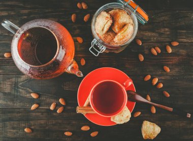 Kavanozda süzme peynirli kurabiye, çay fincanı ve çaydanlıkta siyah çay. Üst görünüm.