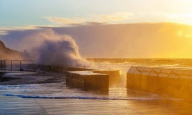 Gün batımında Mornington İskelesi ve Breakwater 'da dalgalar şiddetle eziliyor. Melbourne, Avustralya