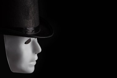 Siyah arka planda siyah silindir şapka giyen beyaz maske profili kopyalama alanı ile izole edildi