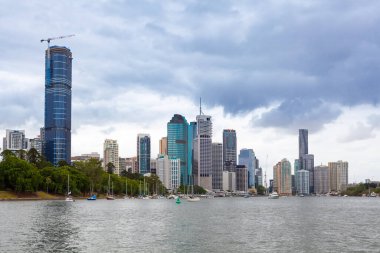 Nehre bakan Brisbane gökdelenleri ve demirlemiş yelkenliler.