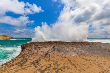 Büyük dalgalar bir kayanın üzerinde patlar. Büyük Okyanus Yolu, Avustralya.