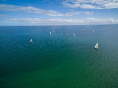 Güneşli bir günde Mornington Yarımadası 'nın sularında yüzen yelkenlilerin hava görüntüleri.