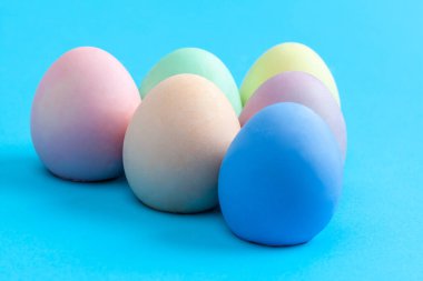 Paskalya yumurtalarının mavi arka planda düz renklere boyanmış aşırı yakın plan fotokopi alanı ile
