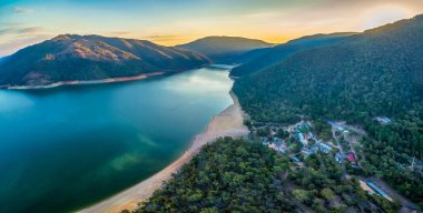 Avustralya 'da günbatımında Burrinjuck Gölü ve orman tepelerinin hava panoramik manzarası