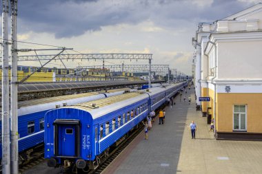 Gomel, Belarus - 27 Haziran 2019: Merkez tren istasyonunda vagonların yanında duran insanlar