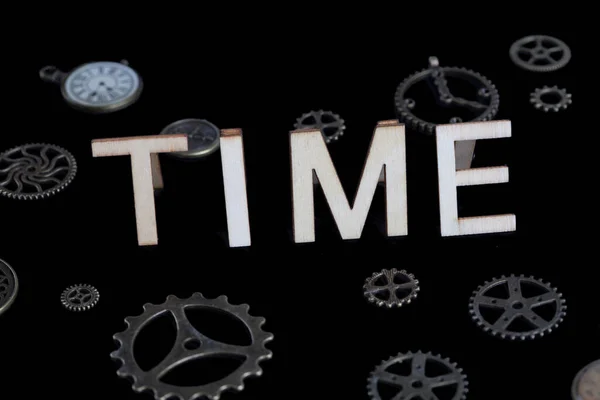 The word Time written on black background with cog wheels and vintage clocks