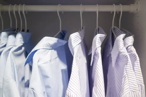 Business striped and smooth shirts hanging in a closet