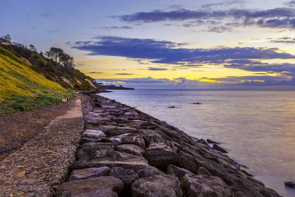 日没時の海岸線と防波堤 — ストック写真