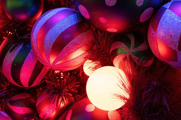 Zbliżenie Świecącej Lampki Świątecznej Między Bombkami Gałęziami Drzew — Zdjęcie stockowe