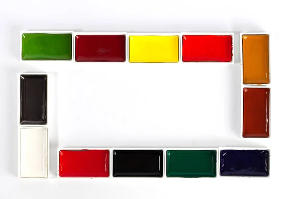 色彩斑斓的固态水彩盘在白色背景上形成一个带有复制空间的框架 — 图库照片