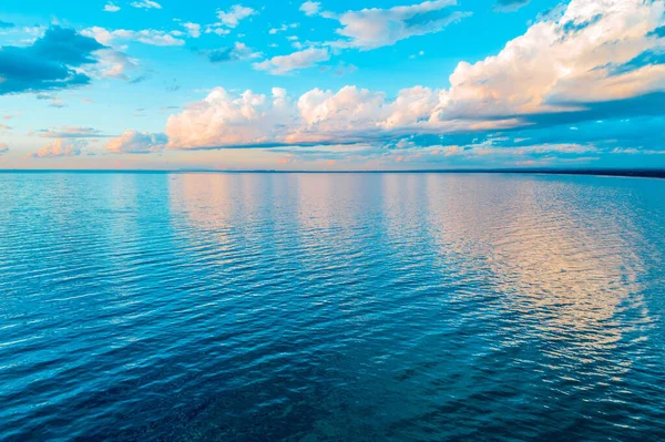 Beautiful minimalism - clouds over calm sea water at sunrise