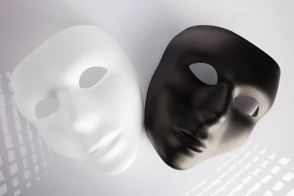 Máscaras Blancas Negras Sobre Superficie Blanca —  Fotos de Stock