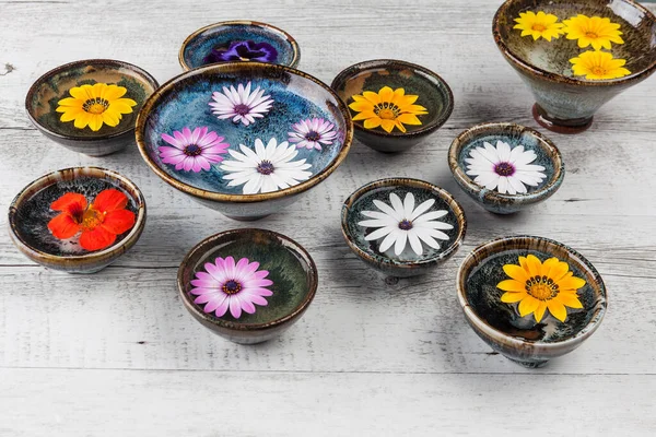 Färgglada Blommor Flyter Vatten Keramiska Skålar Rustika Träbord — Stockfoto