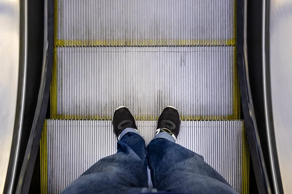 Mężczyzna Nogi Dżinsach Czarne Trampki Stojące Schodach Ruchomych Pov — Zdjęcie stockowe