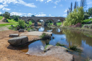 Güneşli bir günde kömür nehri sularına yansıyan ikonik Richmond Köprüsü. Richmond, Tazmanya, Avustralya