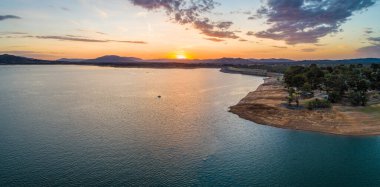 Gün batımında büyük bir gölde küçük bir tekne. Kopya alanı olan havadan bir manzara.
