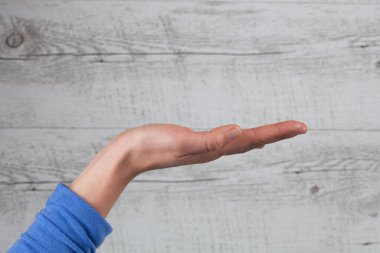 Kadın beyaz ahşap arka planda fotokopi alanı ile el ele ya da jest yapıyor