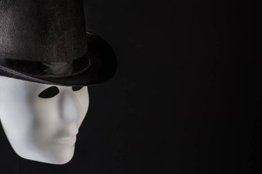 Siyah arka planda siyah silindir şapka giyen beyaz maske profili kopyalama alanı ile izole edildi