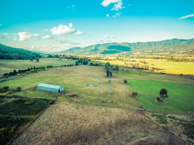 Günbatımında tarımsal tarlalardan ve otlaklardan oluşan hava manzarası