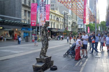 Melbourne, Avustralya - 1 Aralık 2018: Yaşayan heykeltraş bronz adam Noel 'den önce kalabalığı eğlendiriyor