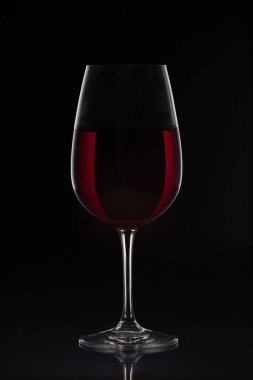 Siyah zemin üzerinde şarap olan kırmızı şarap kadehi