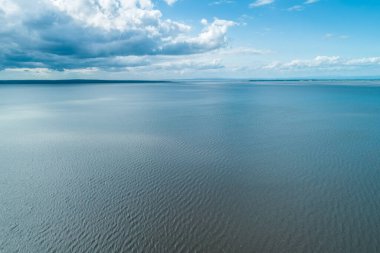 Su dalgalanmaları ve beyaz bulutların minimalist manzarası