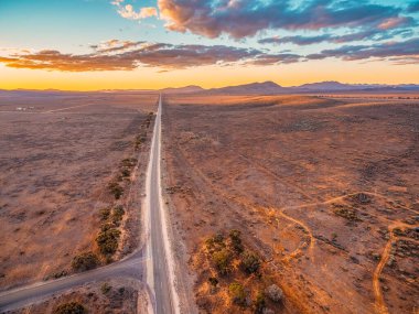 Kırsal otoyol gün batımında Ikara-Flinders Dağları 'na çıkıyor. Hava manzarası.