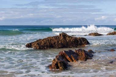 Okyanus dalgaları kopyalanmış kayalara çarpıyor.