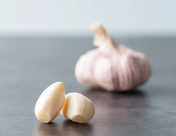 Närbild Två Skalade Vitlöksklyftor Med Suddig Vitlök Bakgrunden Grunt Skärpedjup — Stockfoto