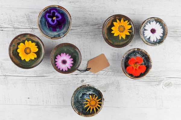 Färgglada Blommor Flyter Vatten Små Keramiska Skålar Rustika Träbord Med — Stockfoto