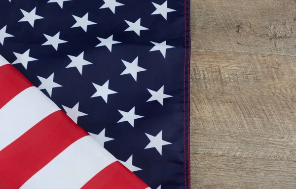 Fragment of American flag folded on wooden walnut table. Horizontal image with copy space.