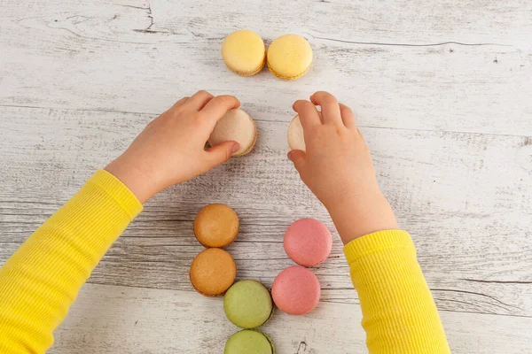 Criança Brincando Com Macarons Mesa Madeira Branca — Fotografia de Stock