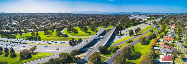 Wide aerial panorama of highway interchange on sunny day