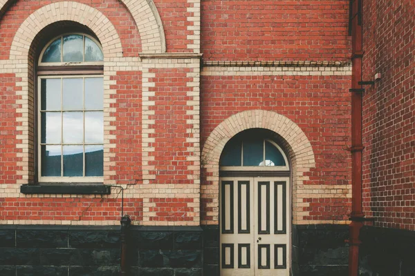 Vintage brick building wall with window and door