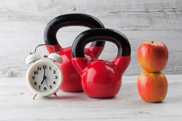 Två Röda Kettlebells Med Äpplen Och Vintage Klocka Rustika Vita — Stockfoto