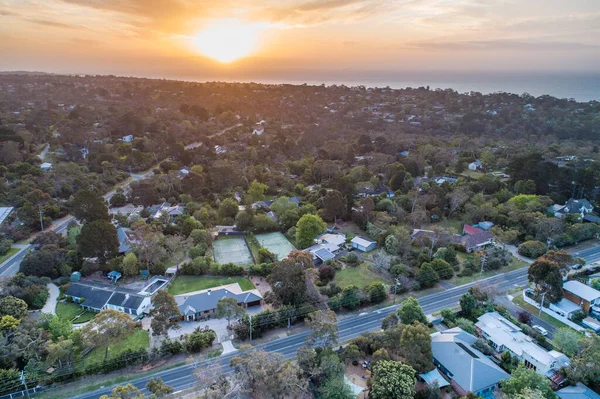 Sunset over houses on ocean coastline - aerial view