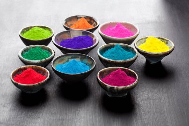 Arka ışıklandırmalı, kirli siyah karatahta bardaklarda renkli Holi pudrası.