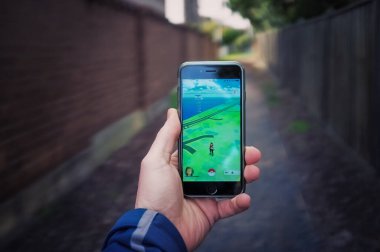 Melbourne, Avustralya - 12 Ağustos 2016: Pokemon Go oyununda iPhone 6 'yı tutan erkek el