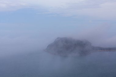 Barrenjoey deniz feneri Yoğun alçak bulutlarla gizlenmiş bir tepenin üzerinde