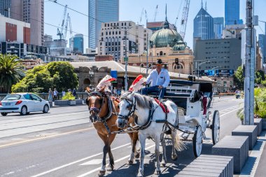 Melbourne, Avustralya - Aralık 2019: Güneşli bir günde Melbourne CBD 'deki Flinders Street istasyonu yakınlarında ünlü çifte at arabası eğlencesi