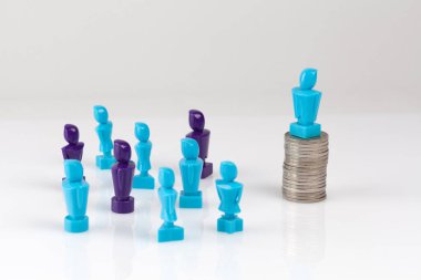 Liderlik ve kurumsal yapı kavramı erkek ve kadın figürleri ve madeni paralarla betimlenmiştir..