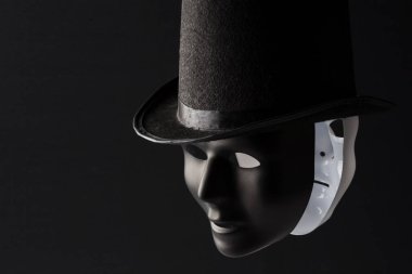 Siyah silindir şapka takan siyah ve beyaz maskeler fotokopi alanı ile izole edilmiş. İkiyüzlülük ve ikiyüzlülük kavramı