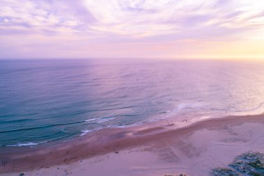 Avustralya 'da gün batımında okyanusun tadını çıkaran insanların hava manzarası.