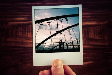 Gün batımında Frankston Köprüsü 'nde yürüyen iki kişinin anlık fotoğraf kartpostalı. Kopya alanı ile hatıra defteri şablonunu seyahat et