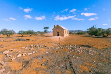 Parlak güneş altında, ender ağaçların arasındaki eski kalıntılar Güney Avustralya 'da turuncu karada.