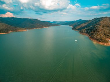 Avustralya 'da gün batımında Eildon Gölü' nde yelken açan teknenin hava manzarası.