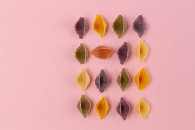 Renkli Conchiglie Rigate makarnası pembe arka planda fotokopi alanı ile