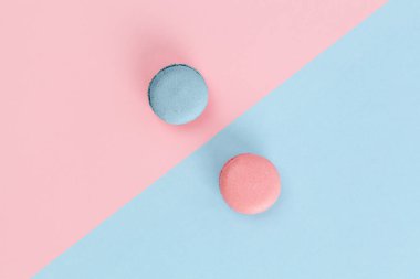 Çapraz arkaplandaki pembe ve mavi badem kurabiyeleri pastel renklerde. Kopyalama alanı olan üst görünüm