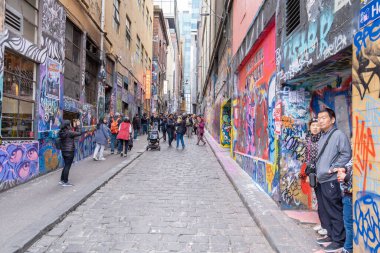 Melbourne, Avustralya - 28 Temmuz 2019: Melbourne CBD 'deki ünlü grafitilerden birine hayran olan turistler