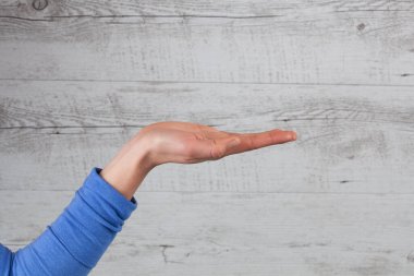 Kadın beyaz ahşap arka planda fotokopi alanı ile el ele ya da jest yapıyor